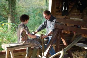 Volunteer Nick Bertenshaw demonstrating how to use the shave horse